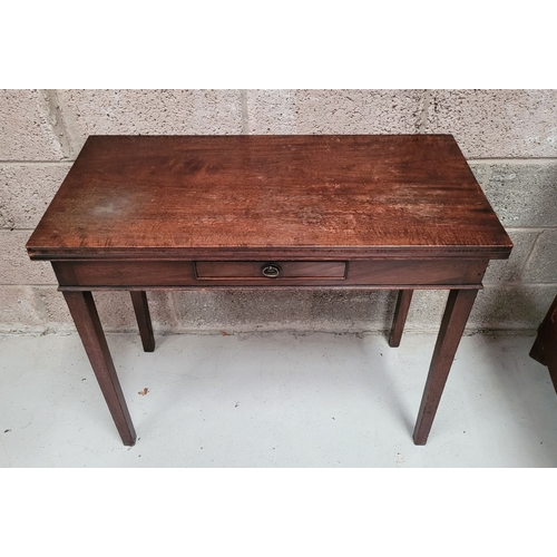 56 - A GEORGIAN MAHOGANY FOLD OVER TEA TABLE, with a single narrow drawer to the front frieze with brass ... 