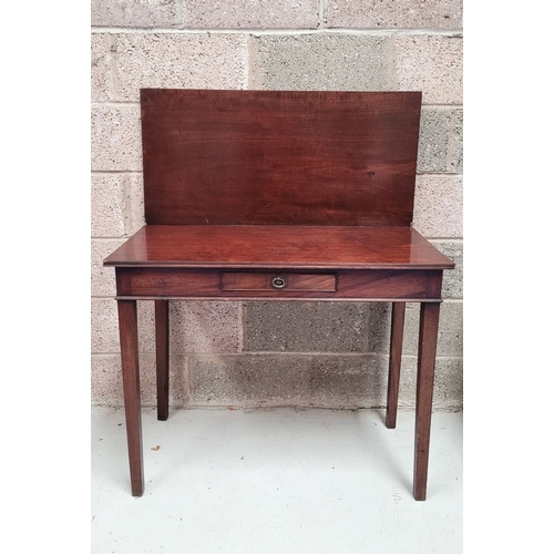 56 - A GEORGIAN MAHOGANY FOLD OVER TEA TABLE, with a single narrow drawer to the front frieze with brass ... 