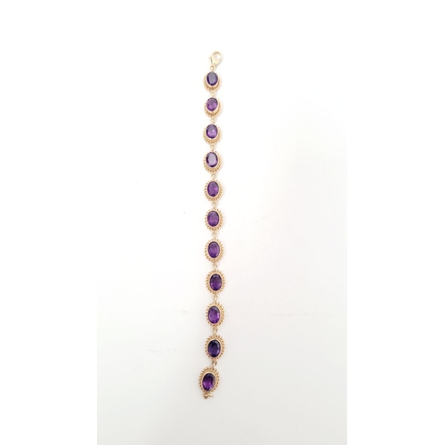 6 - A BEAUTIFUL 9CT YELLOW GOLD AMETHYST BRACELET, 11 oval shaped amethyst stones are set in gold frames... 