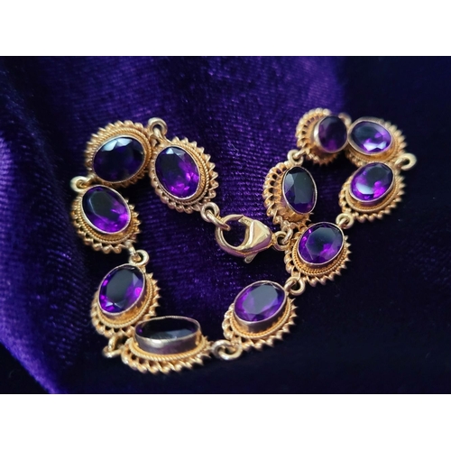 6 - A BEAUTIFUL 9CT YELLOW GOLD AMETHYST BRACELET, 11 oval shaped amethyst stones are set in gold frames... 