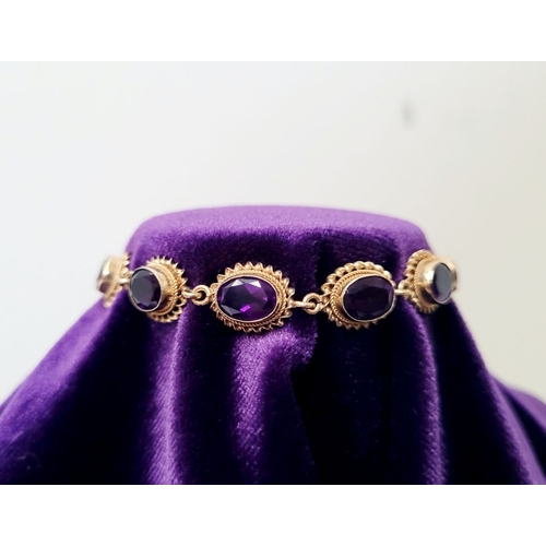 6 - A BEAUTIFUL 9CT YELLOW GOLD AMETHYST BRACELET, 11 oval shaped amethyst stones are set in gold frames... 