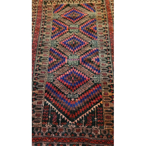 70 - A VERY GOOD QUALITY WOOVEN NEAT SIZED BALUCH FLOOR RUG, with triple diamond shaped medallions to the... 