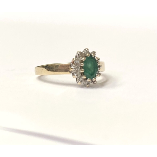 75 - A LOVELY 10CT YELLOW GOLD EMERALD AND DIAMOND CLUTSER RING, with central oval cut emerald in claw se... 