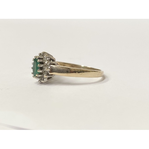 75 - A LOVELY 10CT YELLOW GOLD EMERALD AND DIAMOND CLUTSER RING, with central oval cut emerald in claw se... 