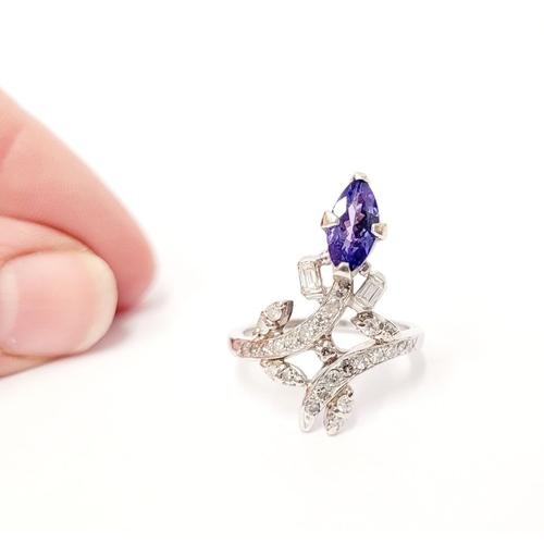 8 - A FANTASTIC VINTAGE TANZANITE & DIAMOND DRESS RING, with an oval shaped tanzanite stone held up on a... 