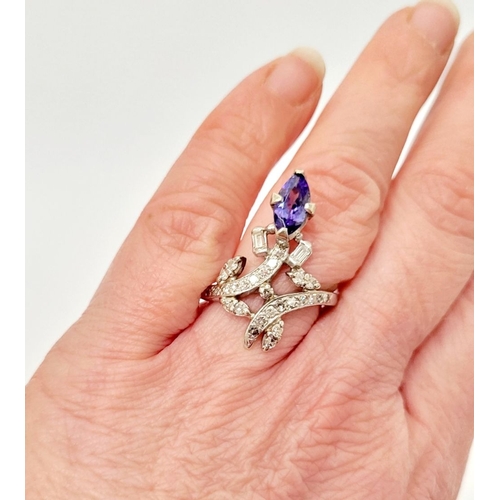 8 - A FANTASTIC VINTAGE TANZANITE & DIAMOND DRESS RING, with an oval shaped tanzanite stone held up on a... 