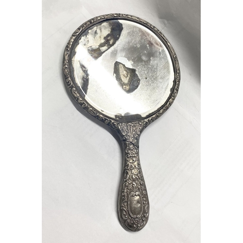 82 - A DECORATIVE SILVER HAND MIRROR, by Henry Matthews, Birmingham c.1929. The bevelled mirror with high... 