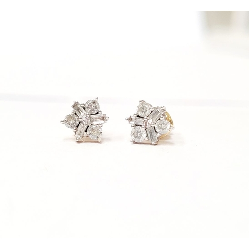 87 - A PAIR OF 9CT YELLOW GOLD BACKED SPARKLING FLORAL DESIGN DIAMOND CLUSTER STUD EARRINGS, with a mix o... 