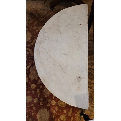 88 - A DEMI LUNE SHAPED MARBLE TOPPED CONSOLE TABLE / HALL TABLE, with carved scroll shaped upright suppo... 