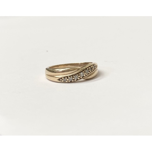 94 - A PRETTY 9CT YELLOW GOLD SEVEN STONE DIAMOND TWIST RING, with seven round cut diamonds in claw setti... 