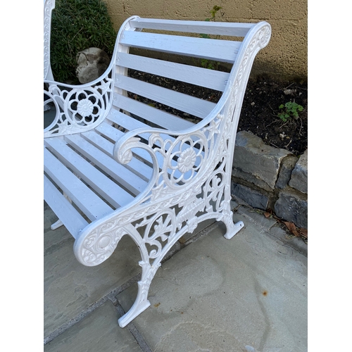 38 - A PAINTED CAST IRON GARDEN SEAT, with decorative scroll supports, slat back and seat. Dimensions: 60... 