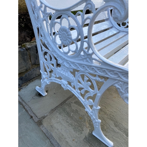 38 - A PAINTED CAST IRON GARDEN SEAT, with decorative scroll supports, slat back and seat. Dimensions: 60... 