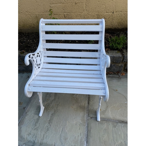 38 - A PAINTED CAST IRON GARDEN SEAT, with decorative scroll supports, slat back and seat. Dimensions: 60... 