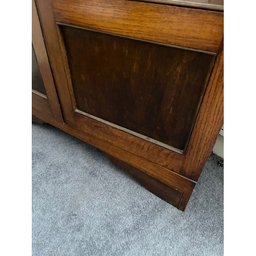 311 - AN IRISH MID-CENTURY BALFE’S OF DUBLIN OAK TWO DOOR GLAZED BOOKCASE, in very good condition, with ad... 