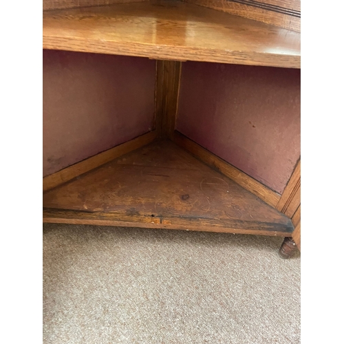 318 - AN OAK MIRROR BACKED CORNER CABINET, to the top is a raised gallery back with turned columns & a fin... 