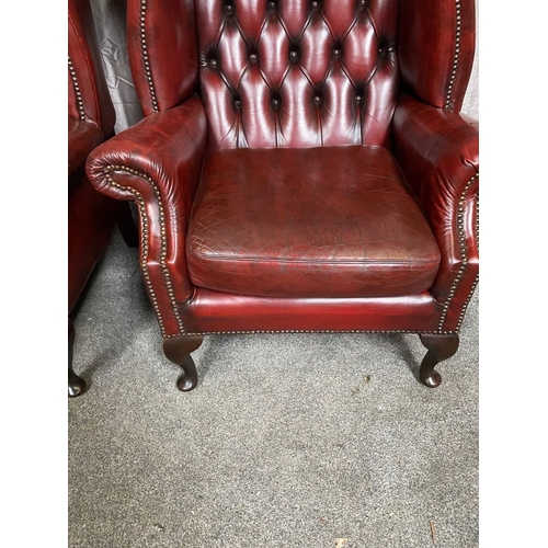 15 - A GOOD PAIR OF OXBLOOD LEATHER WINGBACK CHESTERFIELD ARMCHAIRS, the arched button back upholstered b... 