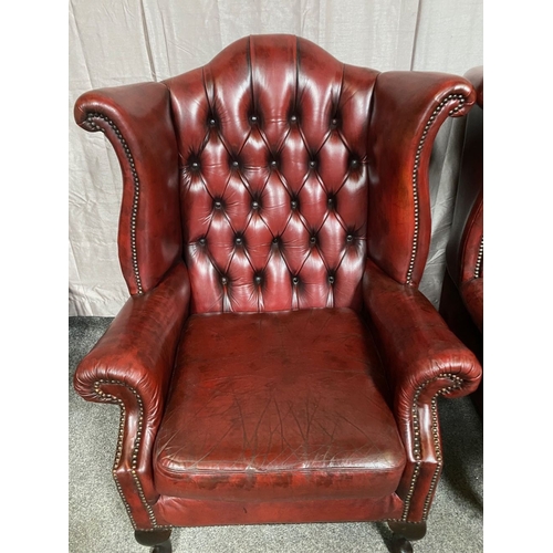 15 - A GOOD PAIR OF OXBLOOD LEATHER WINGBACK CHESTERFIELD ARMCHAIRS, the arched button back upholstered b... 