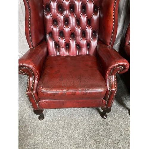 15 - A GOOD PAIR OF OXBLOOD LEATHER WINGBACK CHESTERFIELD ARMCHAIRS, the arched button back upholstered b... 