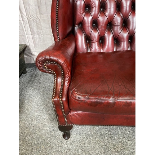 15 - A GOOD PAIR OF OXBLOOD LEATHER WINGBACK CHESTERFIELD ARMCHAIRS, the arched button back upholstered b... 