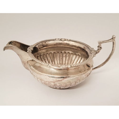 19 - AN IRISH EARLY 19TH GEORGE III SILVER CREAM JUG, with gadrooned rim having floral points, the body f... 