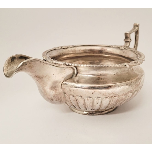 19 - AN IRISH EARLY 19TH GEORGE III SILVER CREAM JUG, with gadrooned rim having floral points, the body f... 