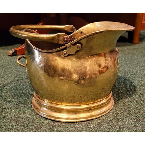 34 - A VERY GOOD QUALITY COAL SCUTTLE, with a swing handle and broad spout, raised on a circular base. In... 