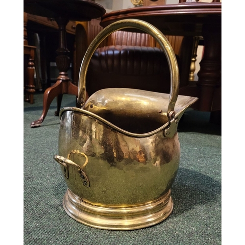 34 - A VERY GOOD QUALITY COAL SCUTTLE, with a swing handle and broad spout, raised on a circular base. In... 