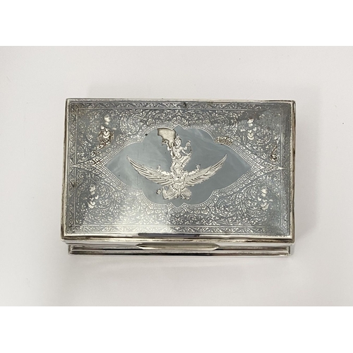 17 - A HIGHLY DECORATIVE THAI STERLING SILVER NIELLO TRINKET BOX, the cover with central design depicting... 