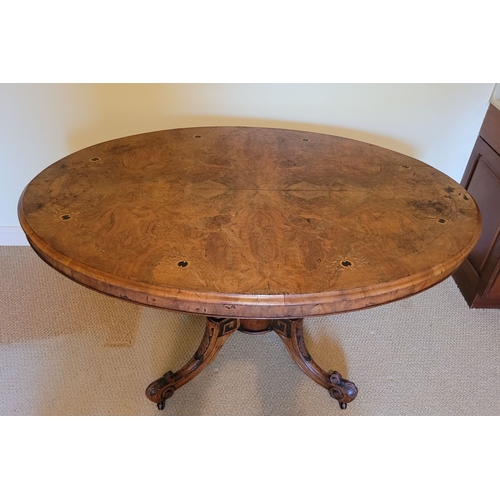 118 - A OVAL SHAPED WALNUT INLAID TIP UP TABLE, the oval top decorated with inlaid detail, with ‘tip-up’ m... 