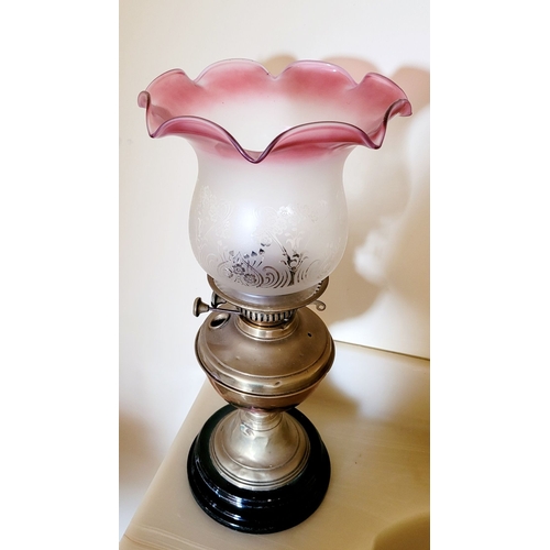 121 - A VICTORIAN CRANBERRY & BRASS OIL LAMP, with a ruffle shaped cranberry & clear glass shade with acid... 