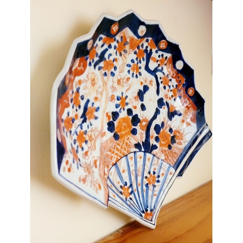 123 - A VINTAGE IMARI FAN SHAPED PLATE, with typical blue & red design. Old hairline mend to the base – ph... 