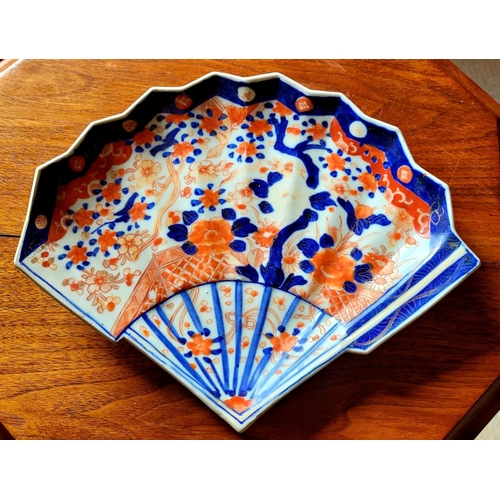 123 - A VINTAGE IMARI FAN SHAPED PLATE, with typical blue & red design. Old hairline mend to the base – ph... 