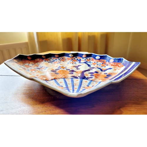 123 - A VINTAGE IMARI FAN SHAPED PLATE, with typical blue & red design. Old hairline mend to the base – ph... 