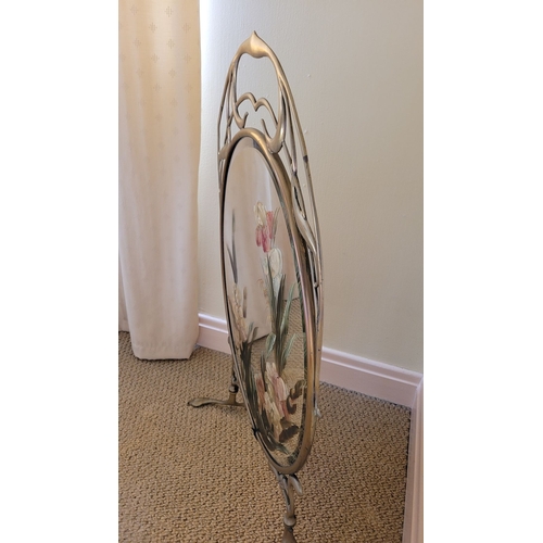 127 - AN ART NOUVEAU BRASS FRAMED MIRRORED FIRE SCREEN, with hand painted floral decoration to the bevelle... 