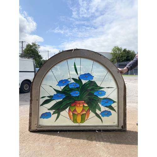 130 - A BEAUTIFUL ARCHED STAINED GLASS WINDOW, c.1993, with blue flowers in vase in vibrant colours, signe... 