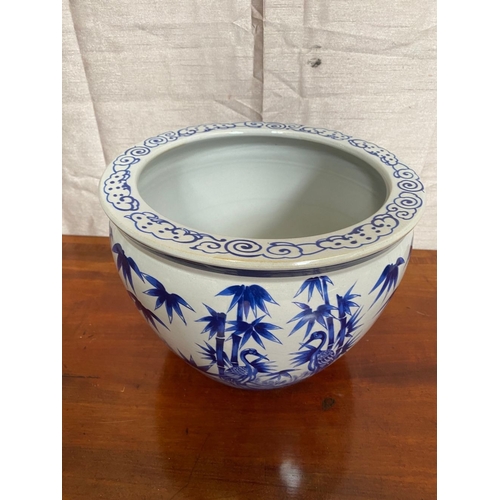 19 - A DECORATIVE BLUE AND WHITE JARDINIERE, with scrolling painted panel to top above painted body depic... 