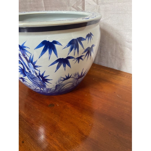 19 - A DECORATIVE BLUE AND WHITE JARDINIERE, with scrolling painted panel to top above painted body depic... 