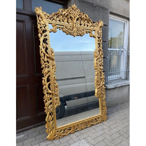 30 - AN EXCEPTIONAL HIGHLY CARVED GILTWOOD OVERMANTLE/HALL MIRROR, with rectangular mirror in extensively... 