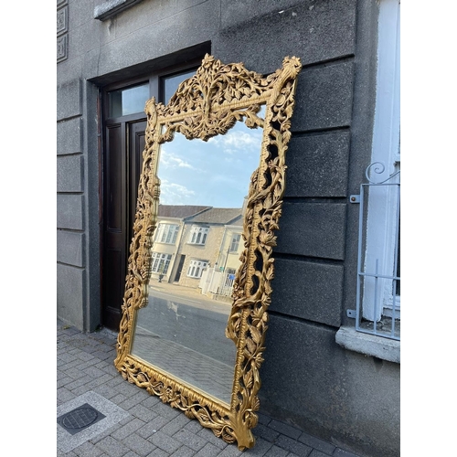 30 - AN EXCEPTIONAL HIGHLY CARVED GILTWOOD OVERMANTLE/HALL MIRROR, with rectangular mirror in extensively... 