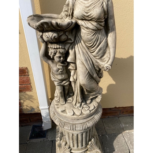 31 - A LARGE STONE GARDEN ORNAMENT IN THE FORM OF MOTHER AND CHILD, child holding birdbath, both raised o... 