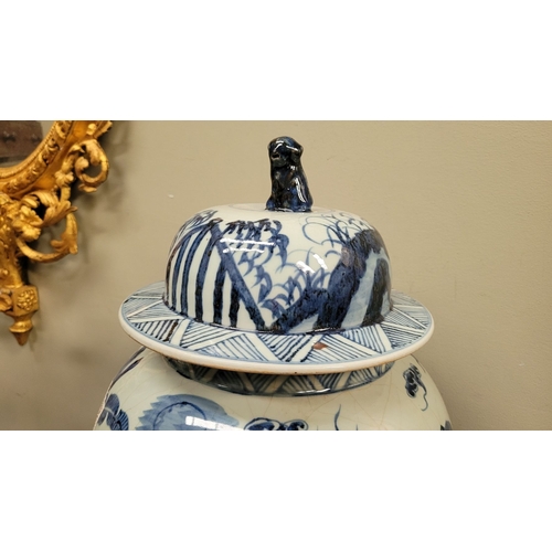 34 - A CHINESE BLUE & WHITE TEMPLE VASE, with domed cover having a lion finial, the vase is painted in bl... 