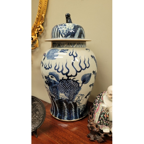 34 - A CHINESE BLUE & WHITE TEMPLE VASE, with domed cover having a lion finial, the vase is painted in bl... 