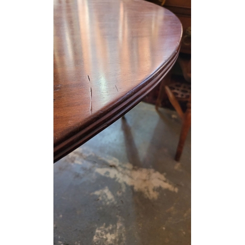 46 - A VERY FINE MAHOGANY OVAL SHAPED DINING TABLE, with reed detail to the edge, raised on a turned colu... 