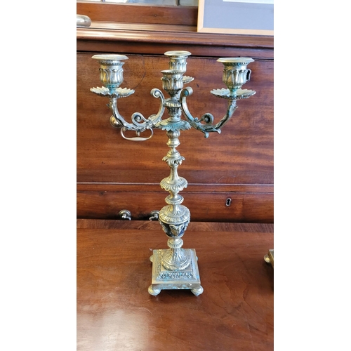 79 - A PAIR OF DECORATIVE BRASS GARNITURES – FOUR HEAD CANDELABRA, each with three outer candle holders a... 