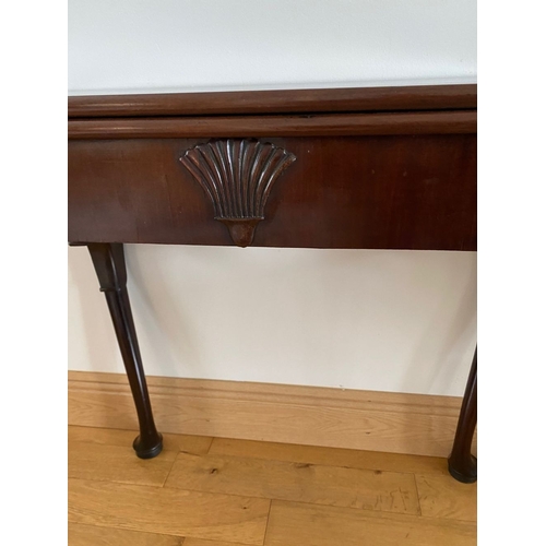 83 - AN IRISH MAHOGANY CARD TABLE, top with porringer corners, above frieze with shell motif to centre. S... 