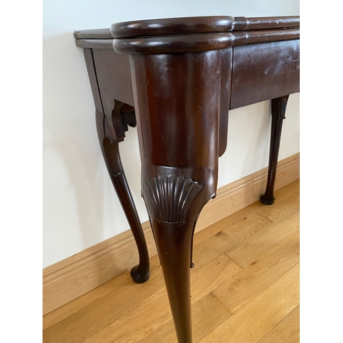 83 - AN IRISH MAHOGANY CARD TABLE, top with porringer corners, above frieze with shell motif to centre. S... 