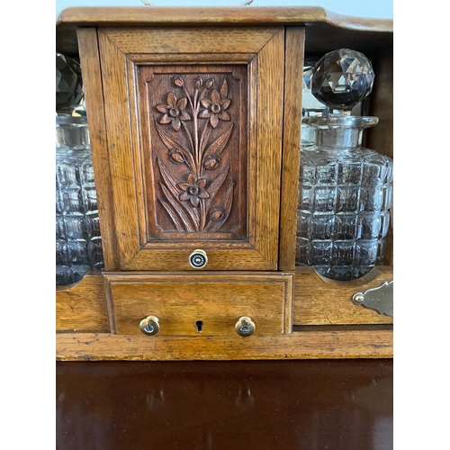 89 - A UNIQUE DECORATIVE OAK TANTULUS WITH TWO CUT GLASS DECANTERS, brass handle and fittings, lift up do... 