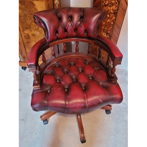 39 - A GOOD QUALITY OX-BLOOD LEATHER CHESTERFIELD STYLE REVOLVING CAPTAINS DESK CHAIR, with padded deep b... 