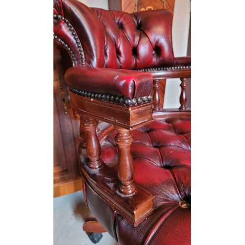 39 - A GOOD QUALITY OX-BLOOD LEATHER CHESTERFIELD STYLE REVOLVING CAPTAINS DESK CHAIR, with padded deep b... 