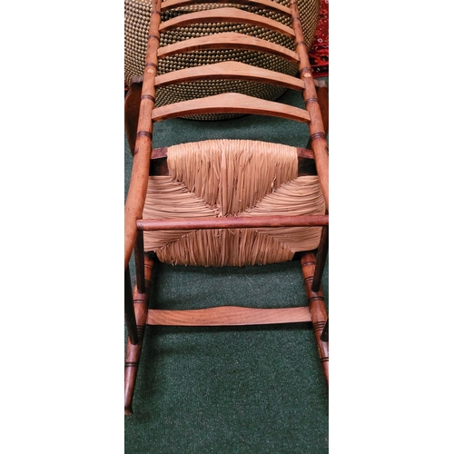 55 - A GEORGIAN STYLE OAK & RUSH LADDER BACK ARMCHAIR, with ring turned uprights to the back and five sha... 